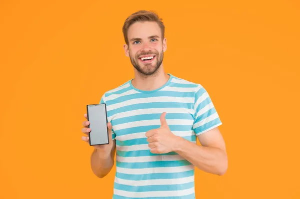 最高の携帯電話がテストされた 幸せな男は電話に親指を与える ハンサムな男は携帯電話を持っている 現代の生活 携帯電話通信 新しい技術だ 今まで以上にスマートフォン — ストック写真