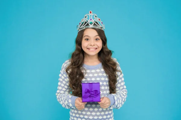 Portrait of cute smiling little girl with gift box. kid in princess crown. happy birthday daughter. Birthday Princess. Kid silver crown symbol of glory. portrait of pride. happy childrens day.