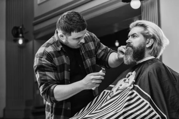 Try different things. hipster at barbershop. bearded client visiting hairdresser. Time for new haircut. man look at mirror reflection. mature handsome man with long hair. barber or hairdresser tool.