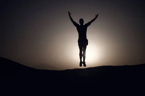 夕焼けにシルエットのスポーツマン 自然景観におけるトレーニングの男 選手は エネルギーと高いをジャンプします 夏の夕暮れにワークアウト スポーツ ウェルネス ボディケアのコンセプト — ストック写真