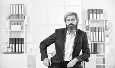 Hayat ve iş hayatı. İş başarısı. Ceketli başarılı sakallı CEO. Kendine güvenen bir yönetici, bir işyeri. Olgun erkek patron. Elleri çapraz iş adamı. Modern ofiste ciddi bir girişimci.