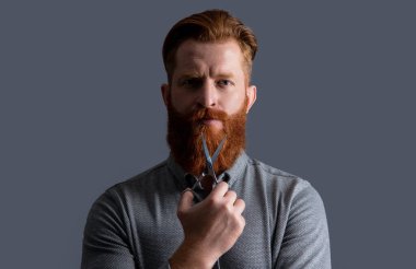 Berber adam kuaförlük için makas tutuyor. Kuaförlük konsepti. Adam berber kuaförlüğü gri arka planda izole edilmiş. Berber makasıyla kuaförlük yapan adam. Kuaför stüdyosunda berber..