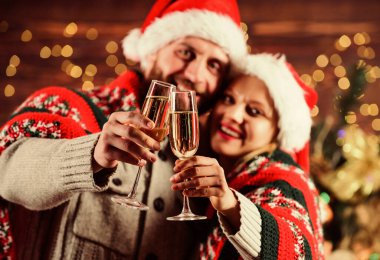 Âşık olmak. Selamlama zamanı. Çift kendini rahat hissediyor. Mutlu noeller. Aile şampanyası. Birbirine aşık çift Noel Baba şapkası. Hediye zamanı. Mutlu yıllar. Tatil kutlaması. Kadınlar ve erkekler xmas 'ı sever.
