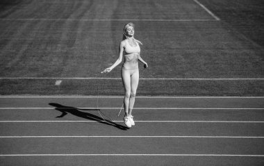 sport woman in sportswear jump on skipping rope on stadium running track before training fitness, jumping.