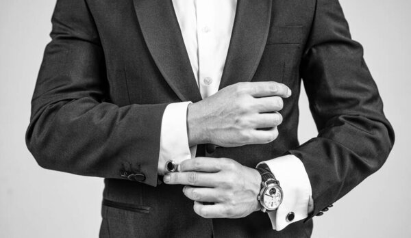 cropped man with wristlet watch on male arm wrist in formal fashion tuxedo, fashion accessory.