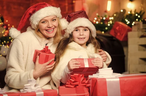 喜びと元気 幸せな家族は新年を祝う メリー クリスマス 母と娘は休日が好きだ サンタ ハットのお母さんと小さな子供の女の子 クリスマスプレゼント箱 プレゼントを開けなさい 冬のショッピング販売 — ストック写真