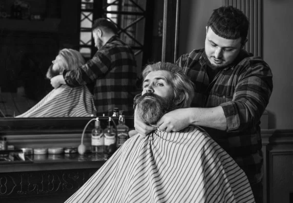 Young and brutal. handsome hairdresser cutting hair of male client. Hairstylist serving client at barbershop. Personal stylist barber. retro and vintage. Designing haircut. barber tools in barbershop.