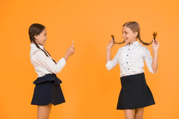 School girls use smartphone to take photo. Girls school uniform. Dont give anyone your password address or any information about your family. Life online. School application smartphone. Personal blog.
