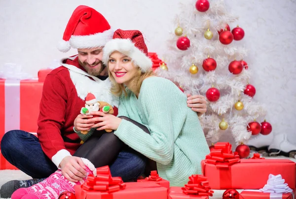愛は最高の贈り物です 愛のカップルはクリスマス休暇のお祝いをお楽しみください 愛する女性と髭の男はサンタの帽子クリスマスツリーの背景を身に着けています クリスマスの前夜に 一緒に新年を始める ロイヤリティフリーのストック画像