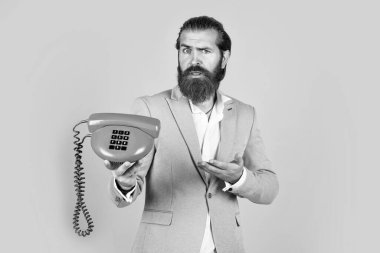 Nasıl kullanılacağını. Bıyıklı vahşi yakışıklı adam telefonda konuşuyor. Ara ve konuş. Modern ve klasik teknoloji. Sakallı hippi retro telefon kullanıyor. iletişim konsepti.