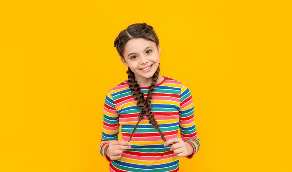 Sarı Arka Planda Örgü Ören Gülümseyen Genç Kız Stüdyoda Saçları — Stok fotoğraf