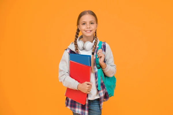 こんにちは 黄色の背景で学校の準備ができて幸せな女の子 小さな子供は本やスクールバッグを持っています 小さな子供は秋に学校に戻ります — ストック写真