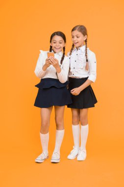 İnternet harika bir kaynak ama erişimin çocuklar için tehlikeleri var. Akıllı telefon kullanan kızlar okulu üniforması. Öğrenci kızlar fotoğraf paylaşmak için cep telefonu ya da akıllı telefon kullanır. Okul başvurusu akıllı telefon.