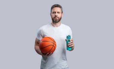 Basketbolcu adam su içiyor. Basketbolcu bir sporcunun fotoğrafı. Spor giyim sektöründe basketbolcu. Gri arka planda izole edilmiş sporcu basketbolcu.