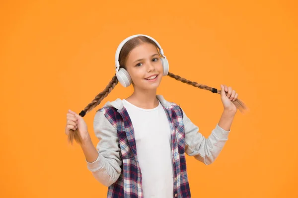 Headphones with wireless technology. Small child listening to music modern wireless earphones. Happy little girl wearing modern headphones. Cute kid enjoying stereo sound. Wireless means freedom.