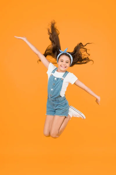 Energy inside. Small girl jump yellow background. Enjoy freedom. Childrens day concept. Spirit of freedom. Active girl feel freedom. Feeling free. Carefree kid. Summer holidays. Jump of happiness.