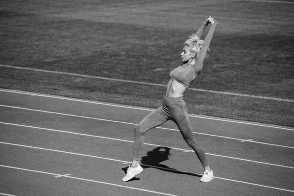性感的女教练穿着运动服在体育场跑道上伸展和热身 健康的生活方式 — 图库照片