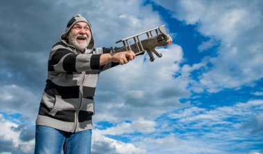 Gökyüzü arka planındaki kıdemli adam, kopyalama alanı. Emeklilikteki son sınıf. Dışarıda oyuncak uçağı olan yaşlı emekli bir adam..