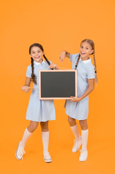 学校のニュース真の情報 小さな女の子は 書き込み表面黄色の背景を保持します 情報を書く子供と黒板 情報のための空白のボード 新鮮な学校情報コピースペース — ストック写真