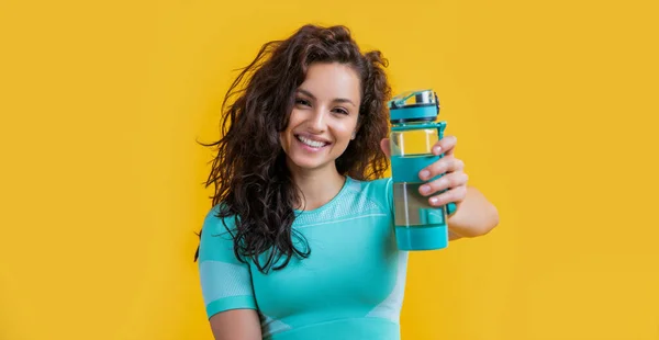 一个快乐的健身女人 带着运动水瓶在工作室里 健康的女人把运动水瓶隔离在黄色的背景下 健康与体育 — 图库照片