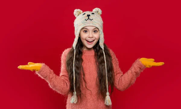 イヤーフラップ ハット ニットウェア イヤフラップ帽子の10代の子供のモデル スペースをコピー 赤い背景に孤立した耳フラップの帽子の10代の子供 スタジオでは10代の子供がセーターとイヤーフラップの帽子を着ています 10代の子供の冬のファッション — ストック写真