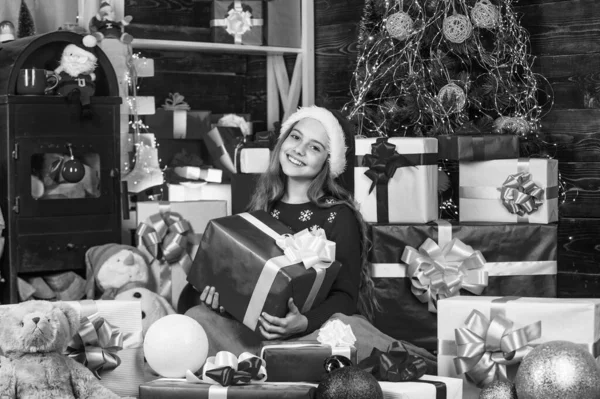 笑顔の店のアシスタント サンタの帽子の子供にはギフトボックスがたくさんある クリスマスマーケットで買い物を成功させました 贈り物で飾られていた 買い物パッケージクリスマスセール 陽気なサンタヘルパー — ストック写真