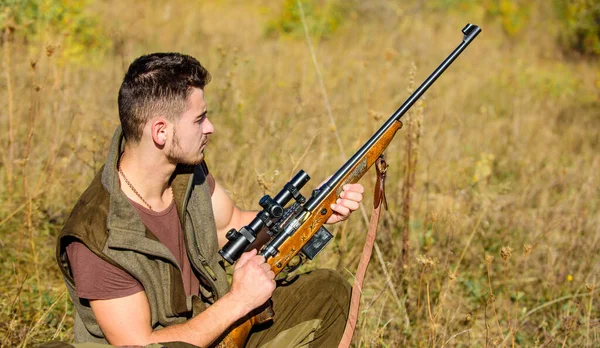 Hunting hobby and leisure. Man charging hunting rifle. Hunting equipment concept. Hunter with rifle looking for animal. Hunter khaki clothes ready to hunt nature background. Hunting shooting trophy.