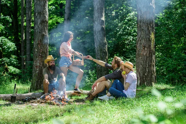 Friends enjoy picnic eat food nature forest background. Plan for perfect day hike picnic. Company friends or family relaxing picnic. Friends relaxing near bonfire. Pleasant hike picnic in forest.