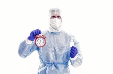 Physician in personal protective equipment hold alarm clock and prescribed Covid-19 medicine for regular intake, reminder.