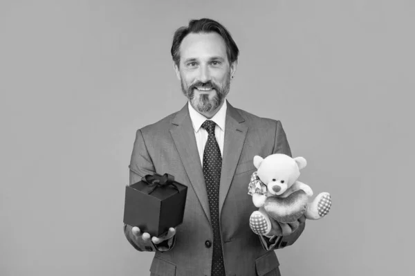 Alegre Homem Sênior Terno Segurar Caixa Presente Urso Brinquedo Fundo — Fotografia de Stock