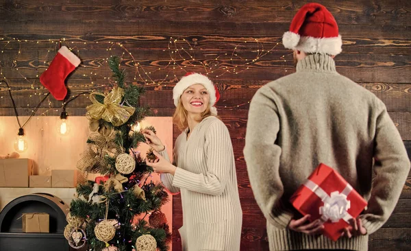 Winter surprise. Man carry gift box behind back. Woman smiling face santa. Christmas surprise concept. Surprising his wife. Giving and sharing. Generosity and kindness. Prepare surprise for darling.