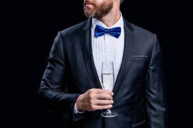 Smokinli tezahüratçının kesilmiş fotoğrafı. Siyah arka planda izole edilmiş smokinli tezahürat yapıyor. Smokinli adam stüdyoda tezahürat yapıyor. Smokinli adam şampanyayla tezahürat yapıyor..