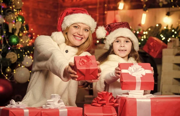 Gifts for girls. Mom and child with gift boxes. Surprise for daughter. Happy holidays. New year tradition. Boxing day. Wrapped gifts near christmas tree. Preparing gifts for family. Winter holiday.