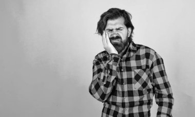 Sakallı ve bıyıklı yakışıklı hippi diş ağrısı ve stomatolojiden muzdarip..