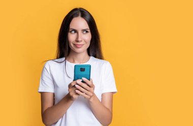 Cep telefonu stüdyosundan mesaj atan bir kadın. Akıllı telefonda cep telefonu uygulaması kullanan bir mesajcı kadın. Kadının mobil iletişimi. Cep telefonuyla sohbet ediyorlar. Telefonu olan kadın, kopyalama alanı.