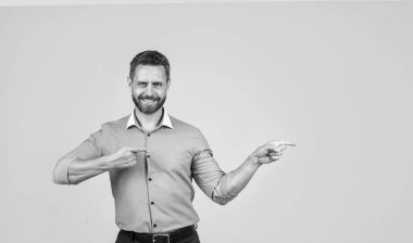 İş başarısı. Başarılı adam fotokopi alanını işaret ediyor. Girişimci ya da yönetici. Erkek günlük iş modası. Yakışıklı profesyonel CEO. Kendine güveniyor patron. Reklam. Tişörtlü olgun iş adamı.