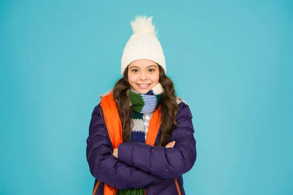 Fashion trend. Little kid wear hat and jacket blue background. Winter sports. Cold season shopping. Child in padded warm coat. Seasonal fashion. Happy winter holidays. Fashion girl winter clothes.