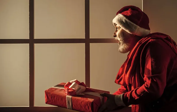 メリー クリスマス 帽子の箱の中の髭のサンタ クリスマスプレゼントとギフトショッピングの時間 冬休みの喜び サンタ クラスの衣装を着た面白い先輩 幸せな新しい2021年 — ストック写真