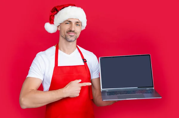 Mogen Man Nyår Santa Hatt Och Rött Förkläde Presenterar Laptop — Stockfoto