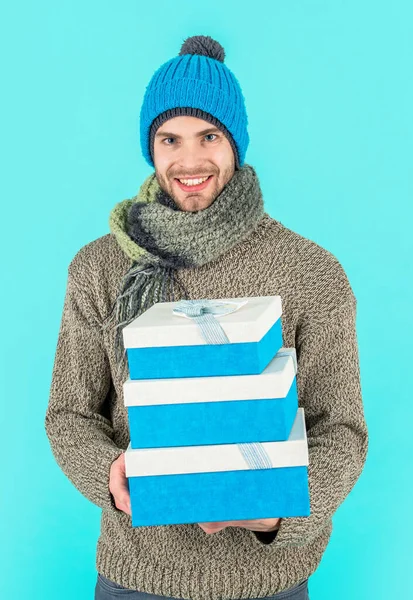 幸せな男は青い背景に隔離された現在の箱を保持します スタジオでプレゼントボックスを持ってる 男はクリスマス休暇のプレゼントボックスを持ってる 冬服の男はプレゼントボックスを持っている — ストック写真
