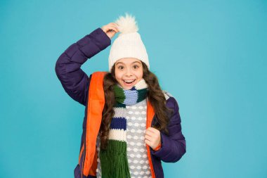 Ne şapka ama. Mutlu çocuk kalın bir şapka takıyor. Küçük kız ponpon şapkalı gülümsüyor. Kış için moda aksesuar. Moda ve tarz. Soğuk hava için sıcak ve şık bir şapka..