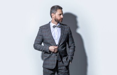 Gri arka planda smokinli beyaz adam. Stüdyodaki smokinli adam. Smokin giyen adamın fotoğrafı. Erkekler smokin giyer..