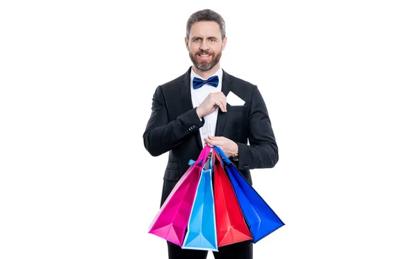 スタジオショットタキシード男ポケットにショッピングバッグとカードを持っている タキシード男の買い物に行く 白い背景に孤立した買い物袋を持ったタキシード男 買い物の後のタキシード男 — ストック写真