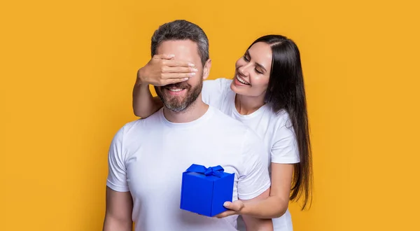 現在の箱と陽気な休日のカップル 休日のサプライズのためにカップルの写真 男性の日 黄色の背景で隔離された驚きのプレゼントを持つカップル プレゼント付きのサプライズカップル — ストック写真