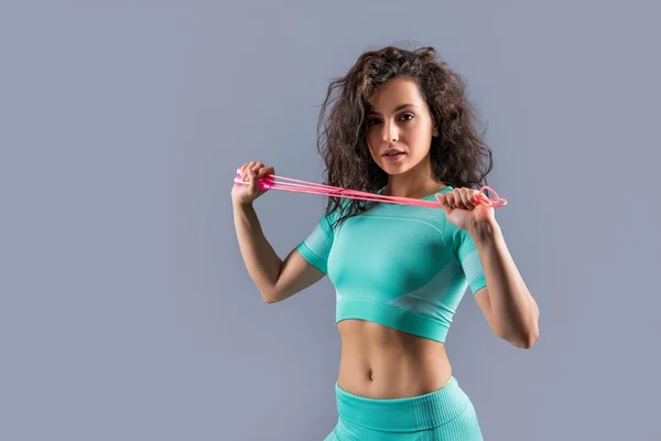 穿着运动服的女运动员拿着健身跳绳演播室 与灰色隔离 健身绳的锻炼 健身锻炼 — 图库照片