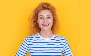 Sarı arka planda izole edilmiş mutlu kızıl saçlı kadın portresi. Stüdyodaki genç kızıl saçlı kadının portresi. Yetişkin kızıl kadın portresi.