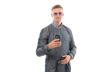 Stüdyoda çay içen mutlu iş adamı, beyaz çay molası. Kahve ya da çay için tek kullanımlık kağıt bardak tutan yakışıklı bir adam..