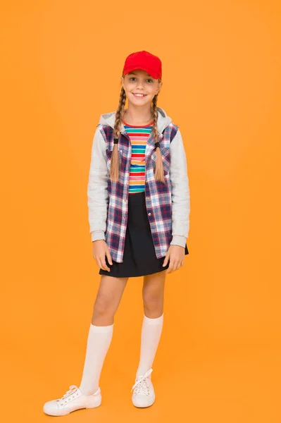 Modern outfit. Rebellious teen. Street style. Cool schoolgirl. Have fun charismatic girl on yellow background. Tomboy concept. Teen age. Girl adorable stylish outfit teenager. Comfortable outfit.