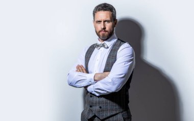 Stüdyoda fotokopi odası olan smokin giyen adam. Smokin giyen bir adamın fotoğrafı. Smokin giyen adam resmi takım elbise giyer. Smokinli adam gri arka planda..