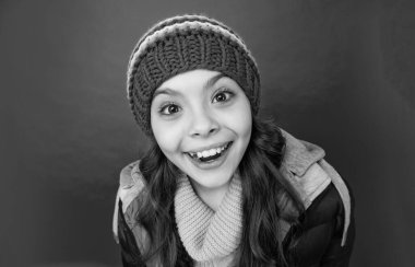 Kış şapkalı mutlu genç kız ve kırmızı arka planda önlüklü, yüzü.